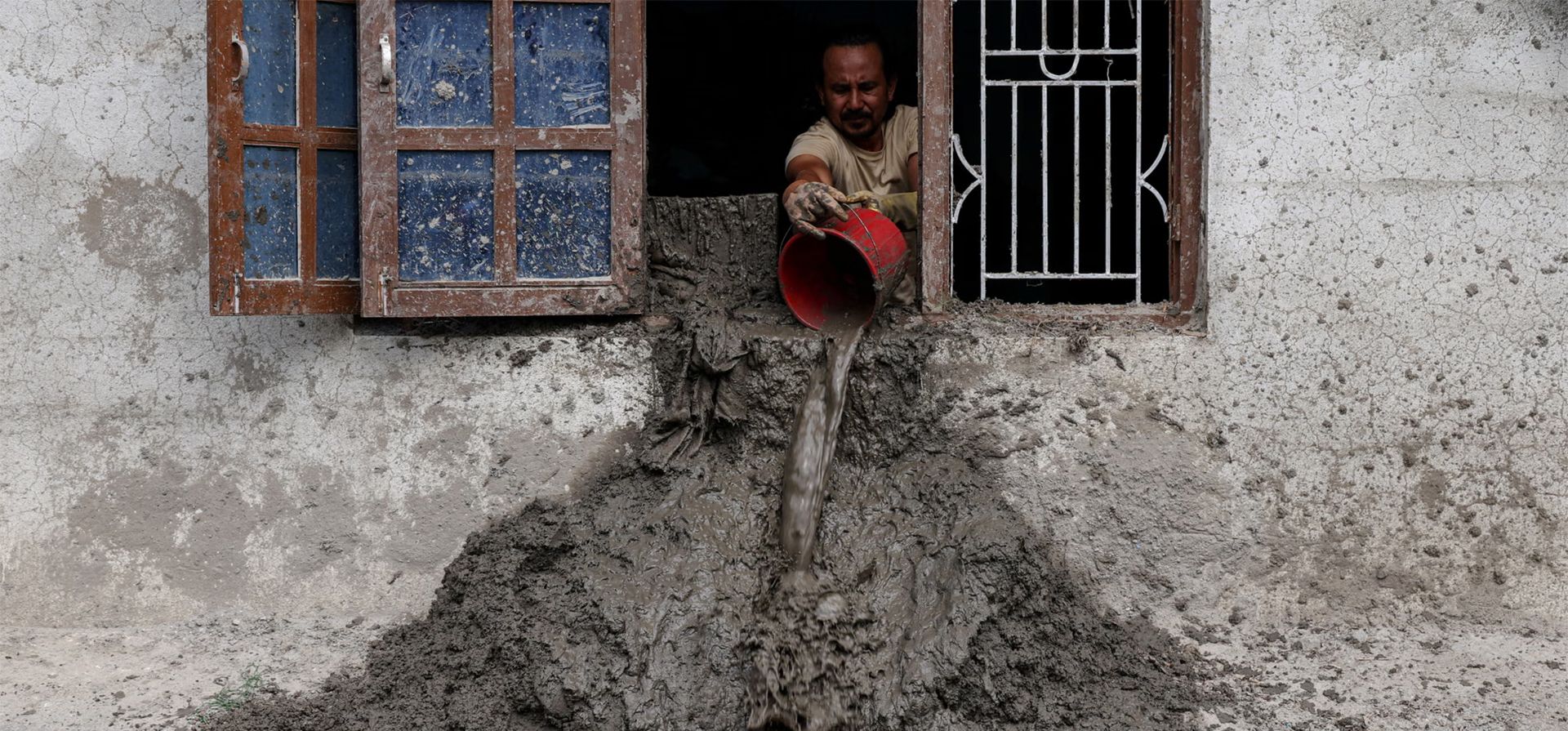 Un hombre arroja barro por una ventana mientras continúan las labores de limpieza tras unas inundaciones repentinas y mortales, Devighat, Nepal. Fotografía: Tyrone Siu/Reuters Un hombre arroja barro por una ventana mientras continúan las labores de limpieza tras unas inundaciones repentinas y mortales, Devighat, Nepal. Fotografía: Tyrone Siu/Reuters