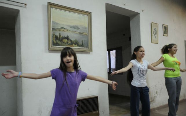 Tres chicas no videntes bailan y se divierten en el grupo de danzas.