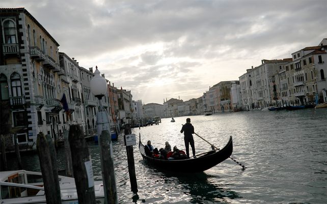 Gondoleros llevan a los turistas a lo largo del Gran Canal. Los países del G-7 dicen que están listos para tomar medidas para amortiguar los impactos económicos del nuevo brote de coronavirus.