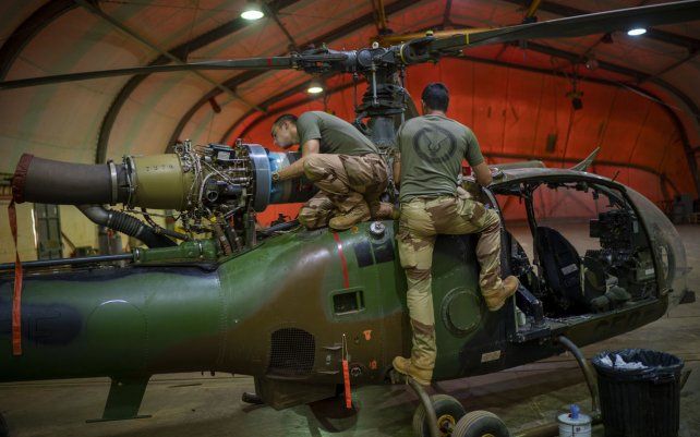 Foto de archivo del martes 8 de junio de 2021, los mecánicos de la fuerza francesa realizan mantenimiento a un helicóptero de combate en su base en Gao, Mali. Francia se prepara para reducir su presencia militar en África.