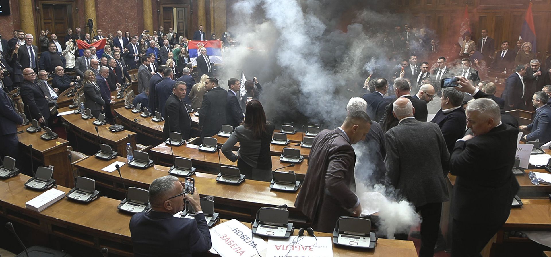 Legisladores de la oposición serbia encienden bengalas y lanzan gases lacrimógenos durante la apertura de la sesión de primavera del parlamento, en señal de apoyo a las protestas contra la corrupción en curso, en Belgrado, Serbia, el martes 4 de marzo de 2025. (RTS Serbia vía AP)