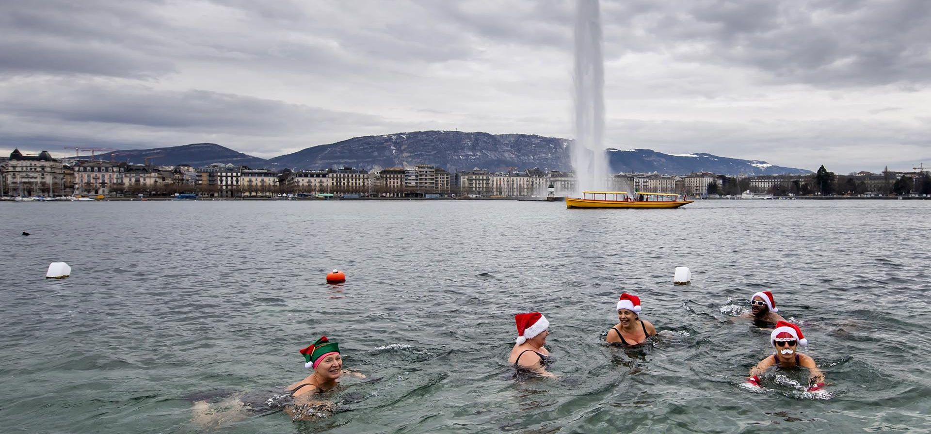 Un grupo de personas con gorros de Papá Noel nadan en el agua del lago Leman, con una temperatura de 5° grados en Bains des Paquis, Ginebra, Suiza. Foto: AP
