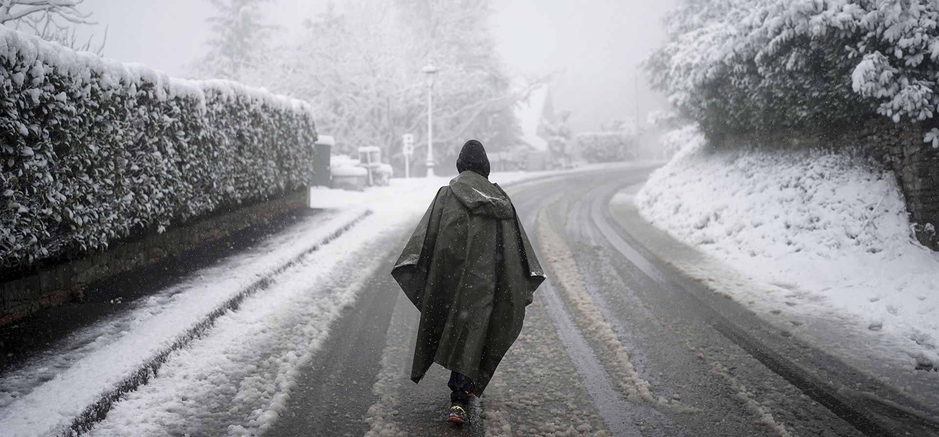 Una mujer camina por una calle nevada en Poleymieux au Mont d
