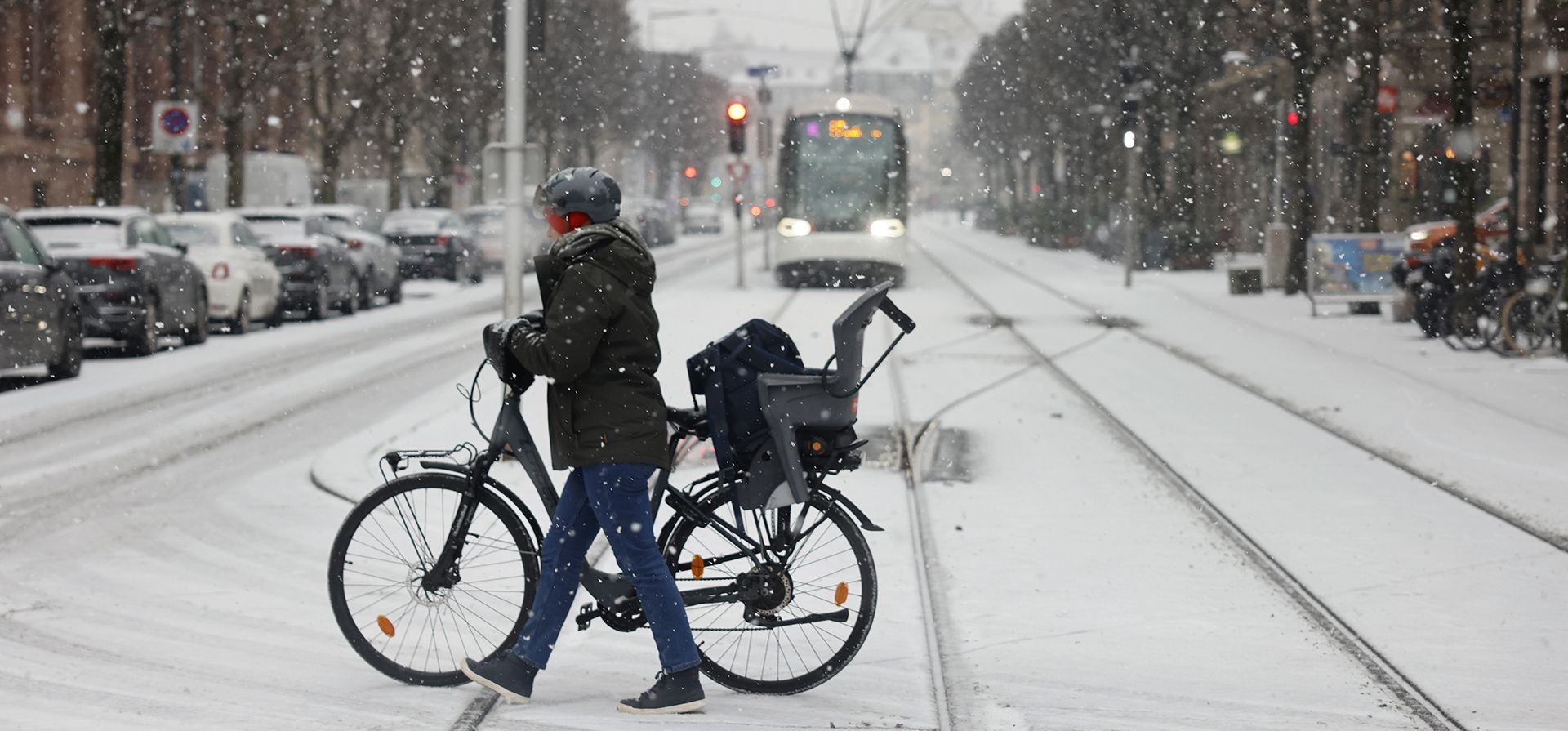Una mujer empuja su bicicleta por un camino cubierto de nieve, el miércoles 14 de diciembre de 2022 en Estrasburgo, este de Francia. (Foto AP/Jean-Francois Badias)