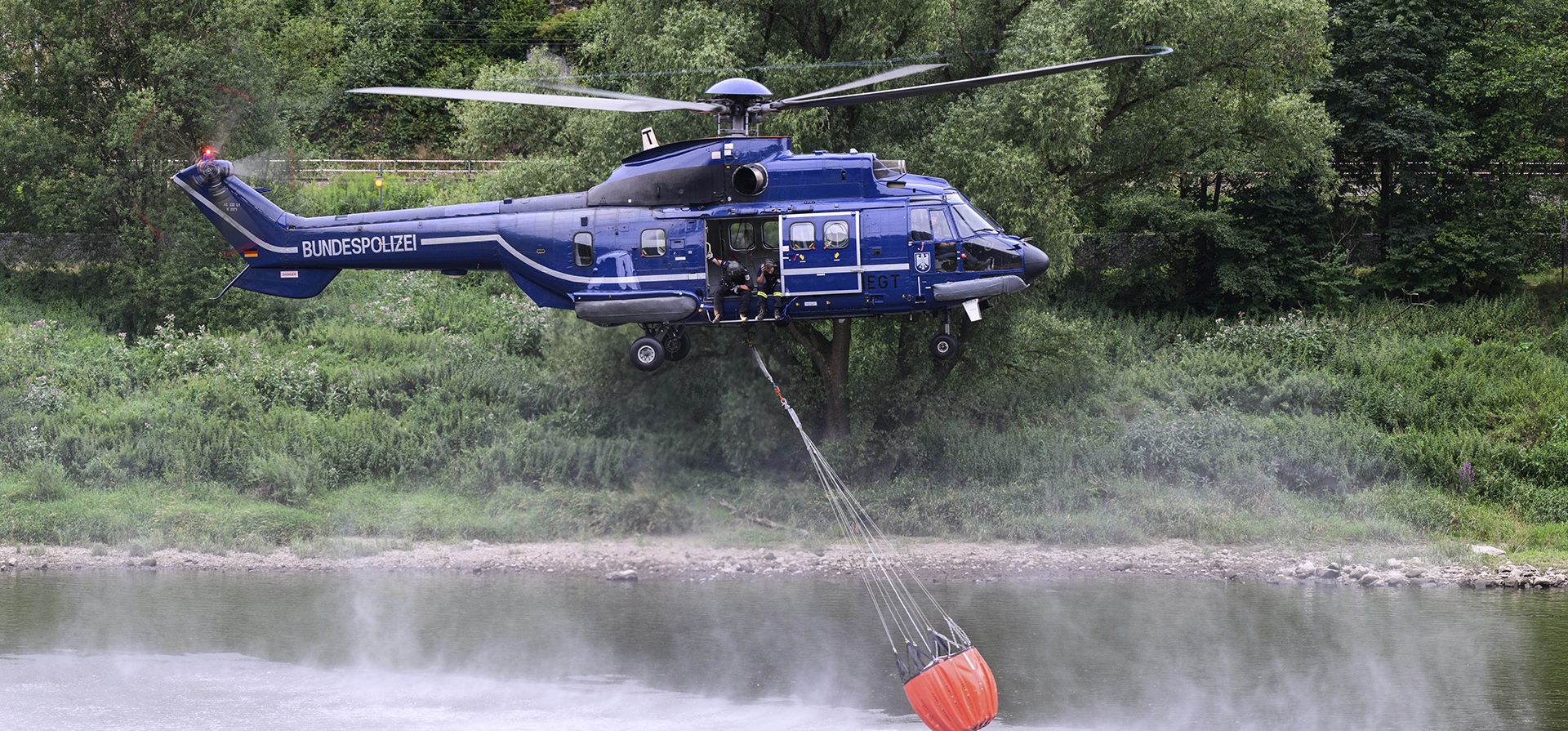 Un helicóptero de la Policía Federal se abastece agua del río Elba para combatir los incendios forestales en el Parque Nacional de la Suiza Sajona cerca de Schmilka, Alemania, el miércoles 27 de julio.