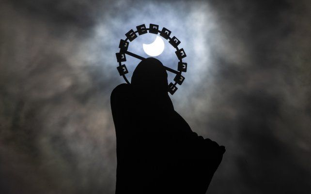 Una estatua de Nuestra Señora, Estrella del Mar en Bull Wall en Dublín, se recorta contra el cielo durante un eclipse solar parcial.
