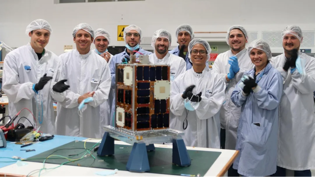 El microsatélite Atenea junto a los científicos que lo fabricaron. Formará parte de la nueva misión de la Nasa que llevará personas a la Luna.