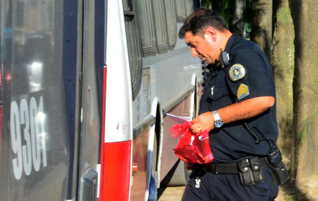 Un policía federal retira el arma que apareció junto al cuerpo del asesor fiannciero Mariano benedit. (Foto: NA)