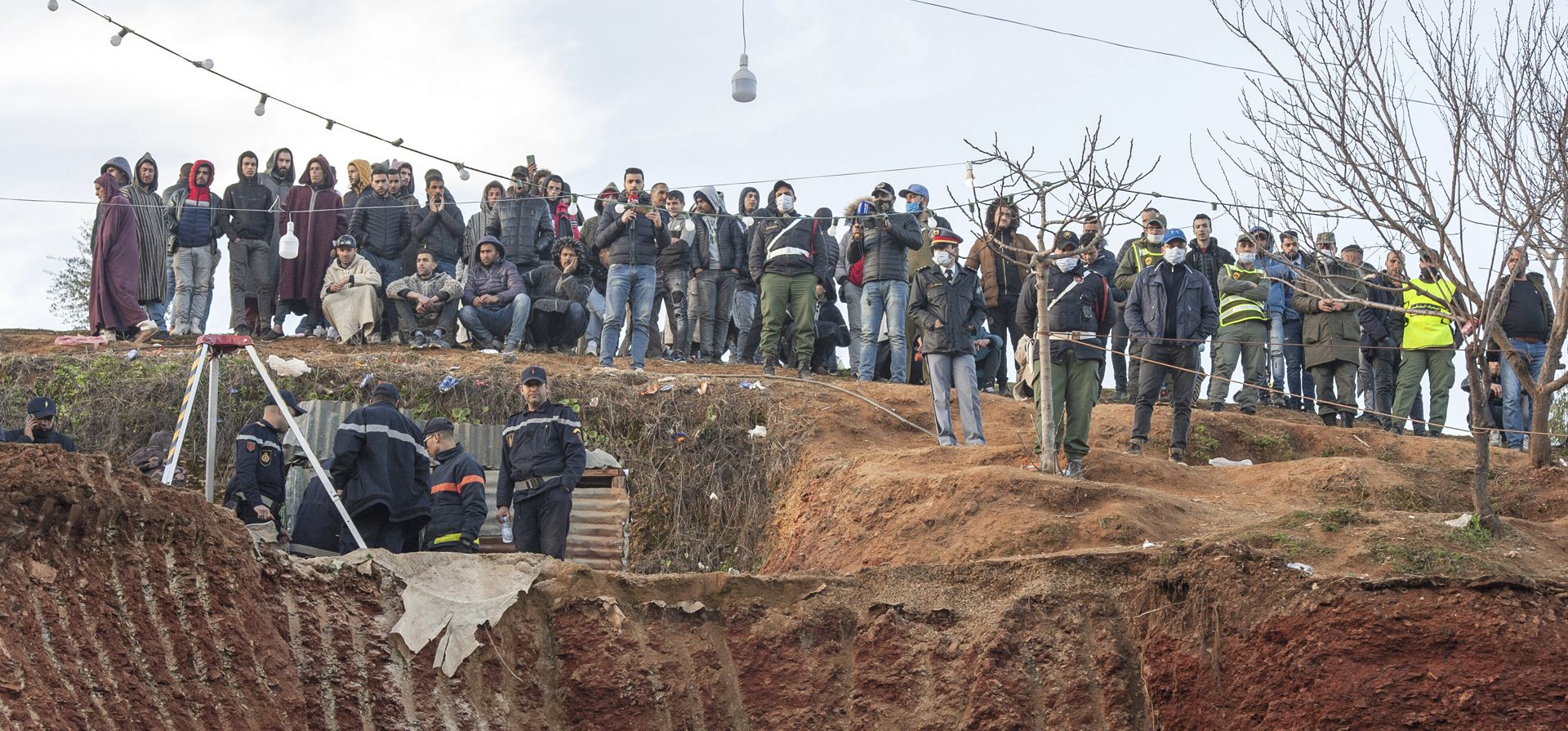 Residentes observan con preocupación cómo la defensa civil y las autoridades locales cavan en una colina mientras intentan rescatar a un niño de 5 años que cayó en un agujero cerca de la ciudad de Bab Berred, cerca de Chefchaouen, Marruecos, el jueves 3 de febrero de 2022.
