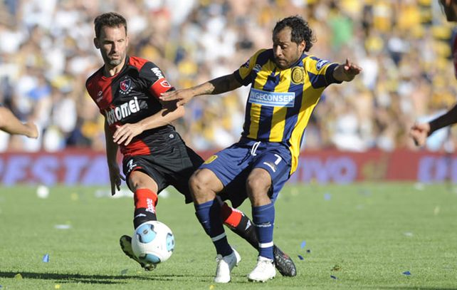 El Sapito Encina disputa la pelota con Lucas Bernardi. Fue la figura del clásico. Foto: H. Río.
