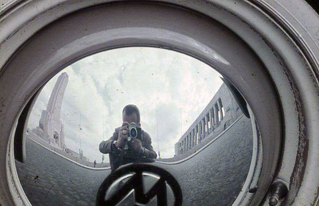 Autorretrato de Hirschfeld reflejado en la rueda de un auto. 