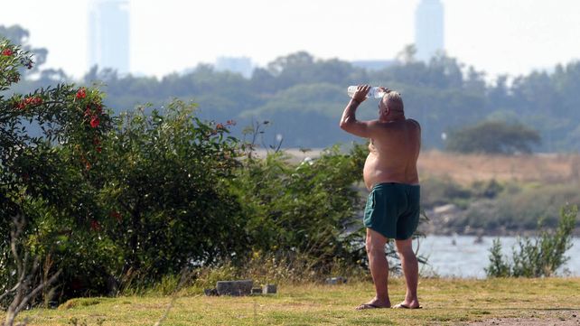 Un señor se refresca con su botella de agua mineral en la reserva ecológica de Caba.