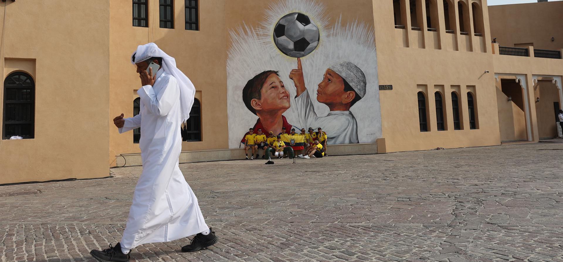 Turistas se toman fotos en un mural en Katara Doha, Qatar, donde se celebra el Mundial de fútbol. EFE/Juan Ignacio Roncoroni  