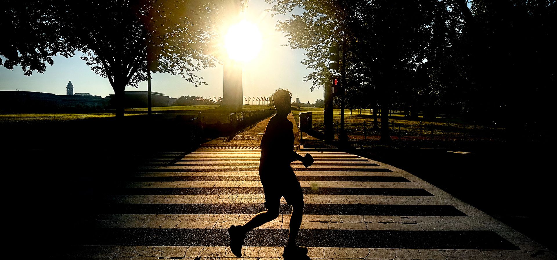 Un corredor cruza la calle 17, cerca del Monumento a Washington, poco después del amanecer, el miércoles 19 de agosto de 2026, en Washington. (Foto AP/Julia Demaree Nikhinson)