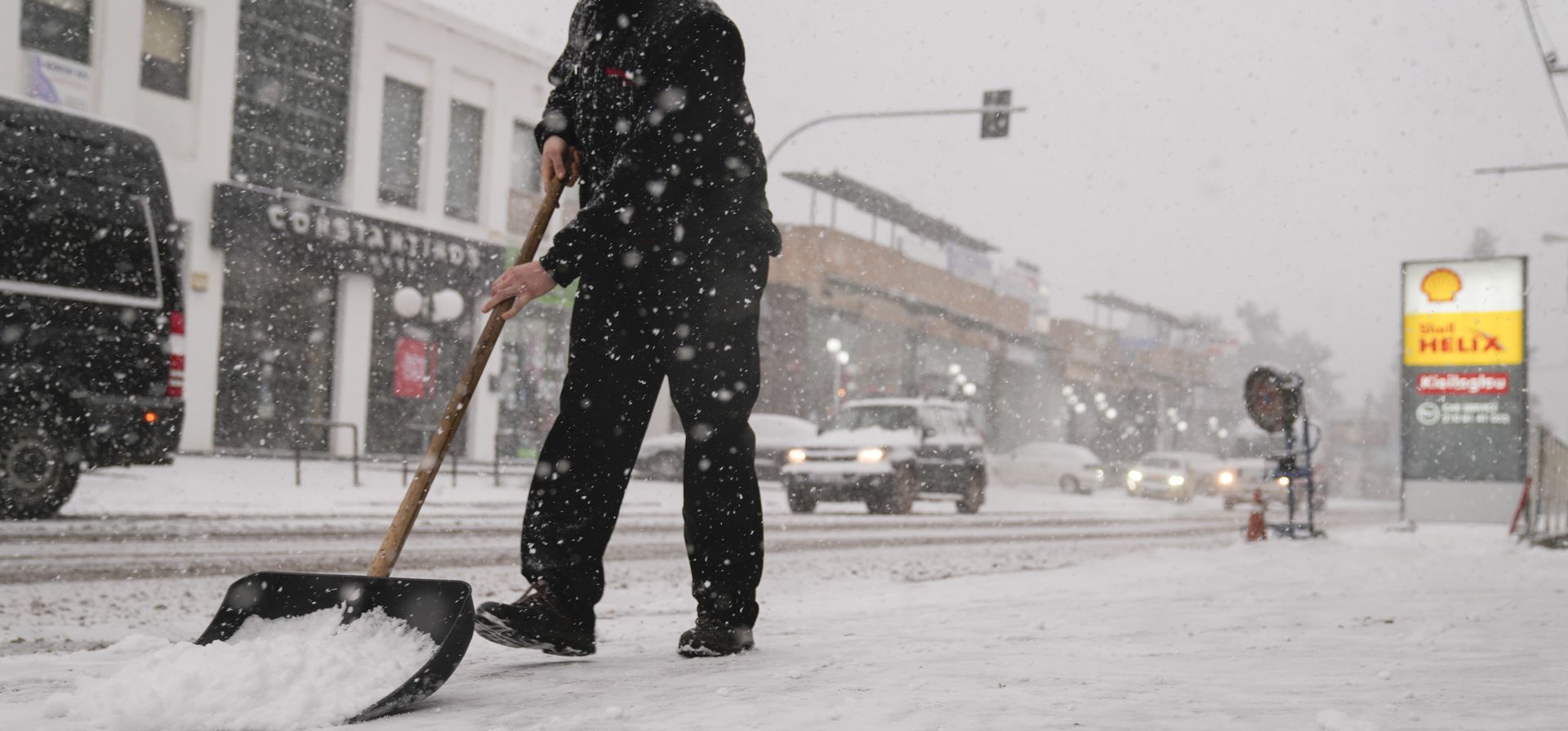 Un hombre palea el pavimento durante una nevada en Agios Steganos, al norte de Atenas. Las autoridades han advertido al público que evite todos los movimientos al aire libre, excepto los esenciales, y varias carreteras y autopistas principales son transitables solo con cadenas para la nieve.