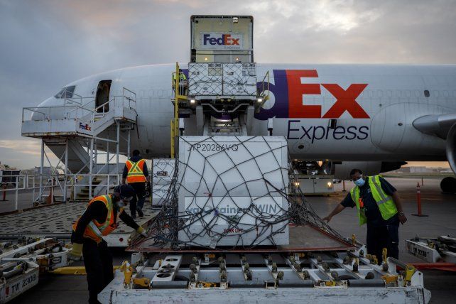 Trabajadores aeroportuarios descargan un envío de la vacuna Moderna COVID-19 en el centro de FedEx en el Aeropuerto Internacional Pearson en Toronto, Australia.