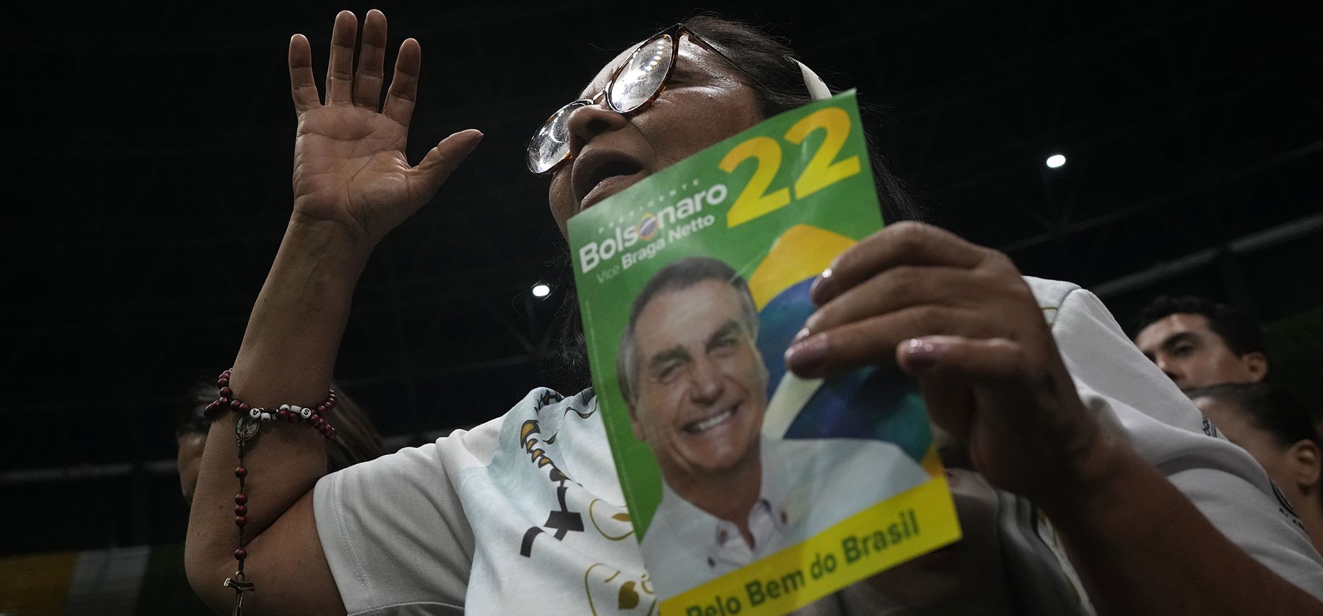 Una mujer católica reza sosteniendo un volante con la imagen del presidente de Brasil, Jair Bolsonaro, quien se postula para la reelección, durante un evento religioso en Brasilia, Brasil, el martes 18 de octubre de 2022. Bolsonaro competirá contra el expresidente Luiz Inacio Lula da Silva en una segunda vuelta de las elecciones presidenciales el 30 de octubre.