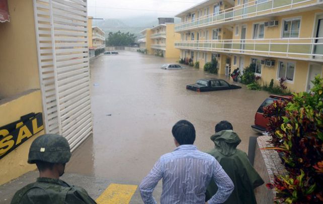 Soldados del ejército observan una calle inundada frente a un complejo de viviendas. 2) Turistas caminan por la playa cubierta de restos y basura.