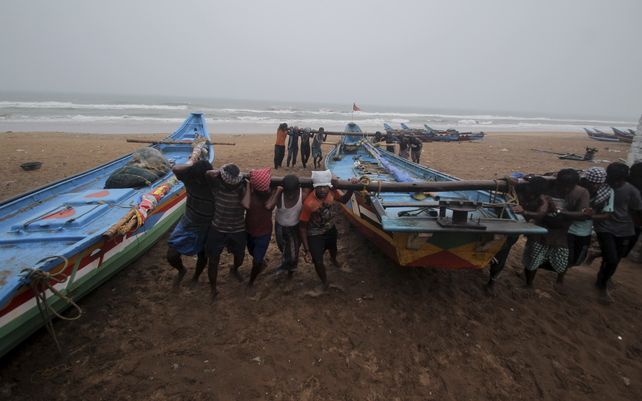 Pescadores trasladan sus botes a terrenos más seguros como precaución contra el ciclón Yaas en la playa Puri en la bahía de Bengalcoast en Odisha