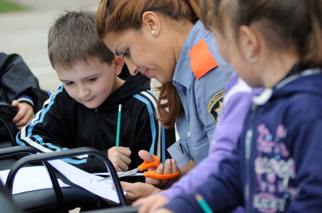 Agentes de la Policía Comunitaria junto a chicos y vecinos realizando el mural.
