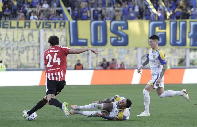Ávila se queja de un golpe, mientras el volante centra Ibarra trata de evitar el avance del jugador de Estudiantes.