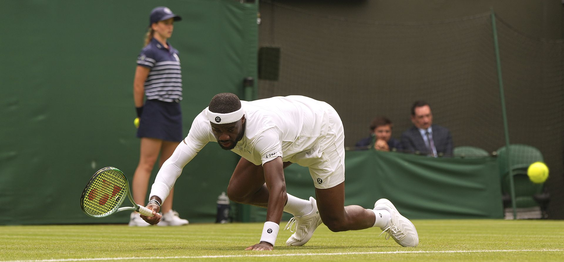 Frances Tiafoe, de EE.UU., resbala en el césped tras ser derribado por Cameron Norrie, de GB, durante su partido single de segunda ronda del Torneo de Tenis de Wimbledon en Londres, el miércoles 2 de julio de 2025. (Foto AP/Alastair Grant)