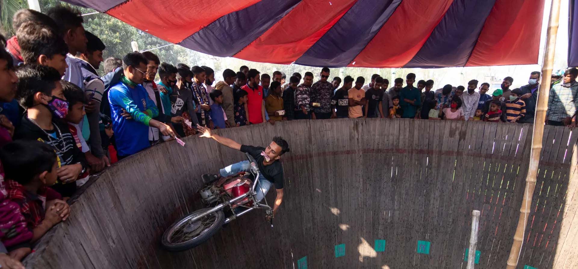 Audaces motociclistas entretienen a los espectadores conduciendo alrededor de un muro vertical de la muerte, mientras reciben dinero de la gente, Khulna, Bangladesh. Fotografía: Joy Saha/ZUMA Press Wire/REX/Shutterstock