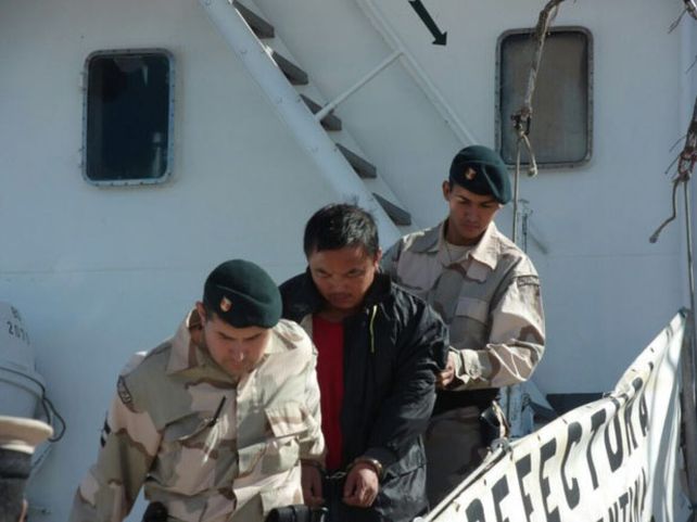 arrestado. El capitán del barco chino conducido por los guardias. Sería el único comprometido de la tripulación.