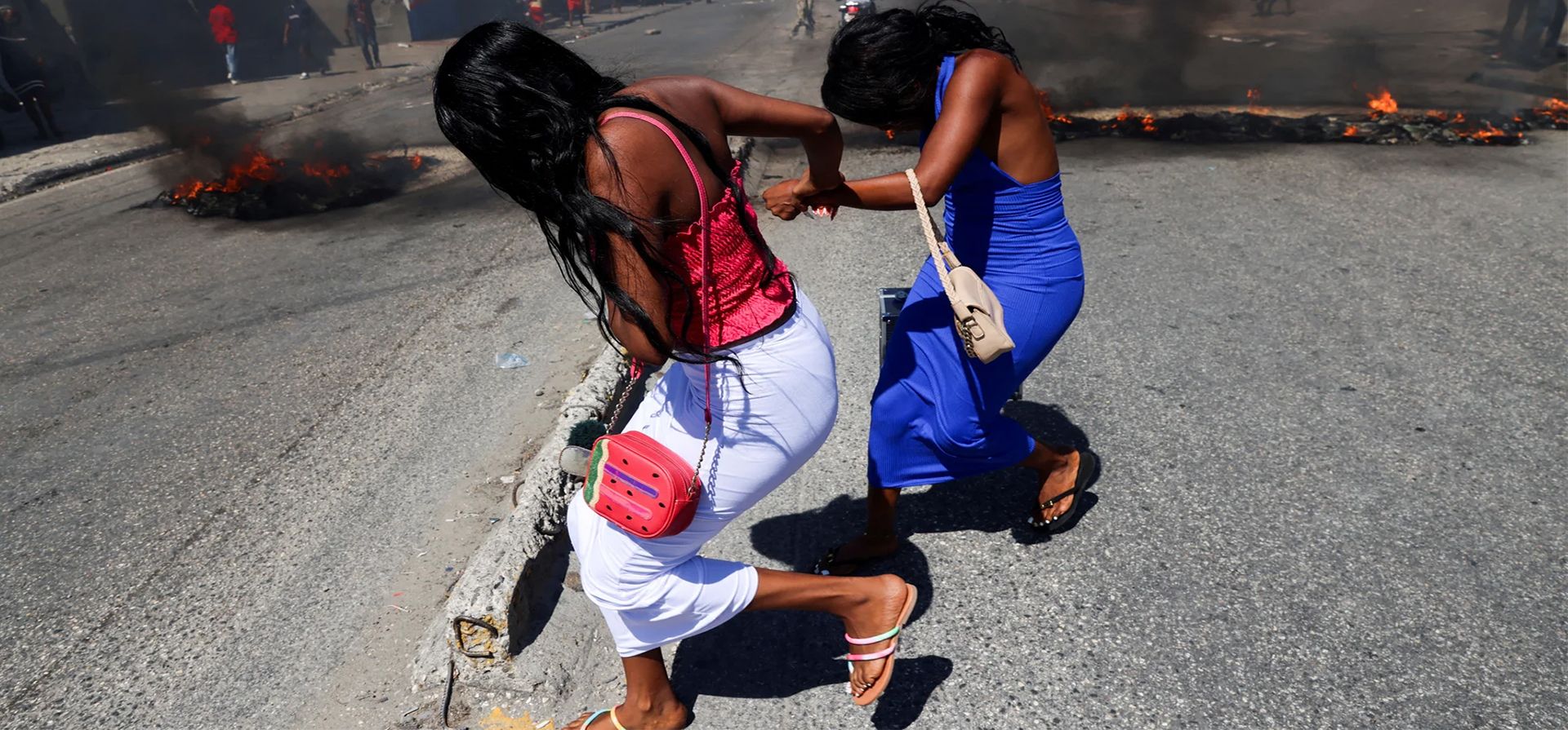 Las mujeres corren junto a las barricadas en llamas en las calles del distrito de Solino mientras los residentes piden ayuda al gobierno y protestan por la falta de seguridad, Puerto Príncipe, Haití. Fotografía: Ralph Tedy Erol/Reuters Las mujeres corren junto a las barricadas en llamas en las calles del distrito de Solino mientras los residentes piden ayuda al gobierno y protestan por la falta de seguridad, Puerto Príncipe, Haití. Fotografía: Ralph Tedy Erol/Reuters