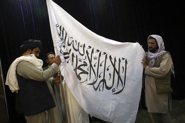 Talibanes despliegan su bandera, blanca con una inscripción islámica en árabe, en el palacio presidencial de Kabul. Remplaza a la anterior bandera tricolor, de la extinta república afgana. 