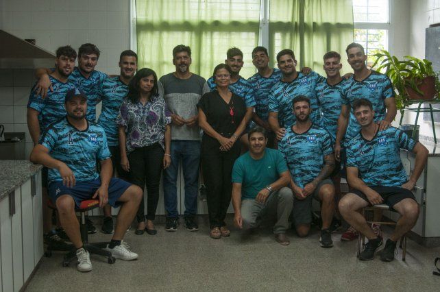 La Selección Argentina de sóftbol junto a los directivos de la escuela.