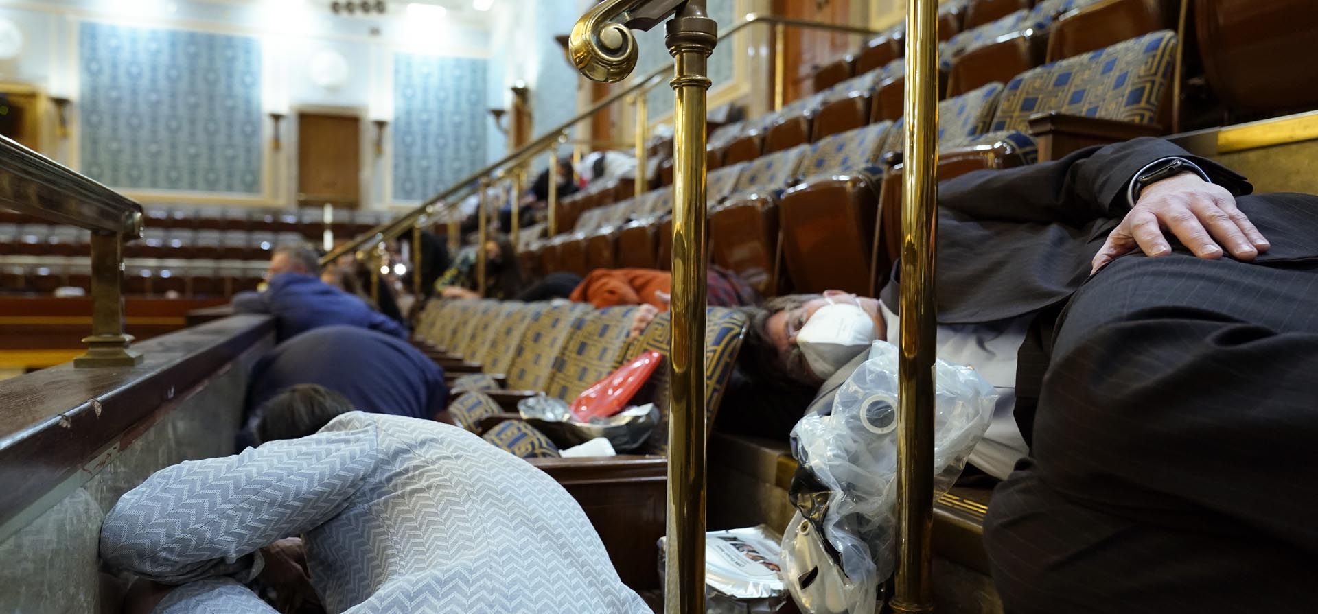 Miembros del Congreso usan máscaras de gas de emergencia cuando son evacuados de la galería de la Cámara mientras los manifestantes intentan irrumpir en la Cámara del Capitolio de los Estados Unidos el 6 de enero de 2021 en Washington. 