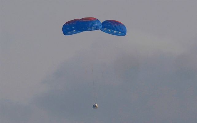 La cápsula New Shepard de Blue Origin se lanza en paracaídas de manera segura hasta el área de lanzamiento con los pasajeros Jeff Bezos