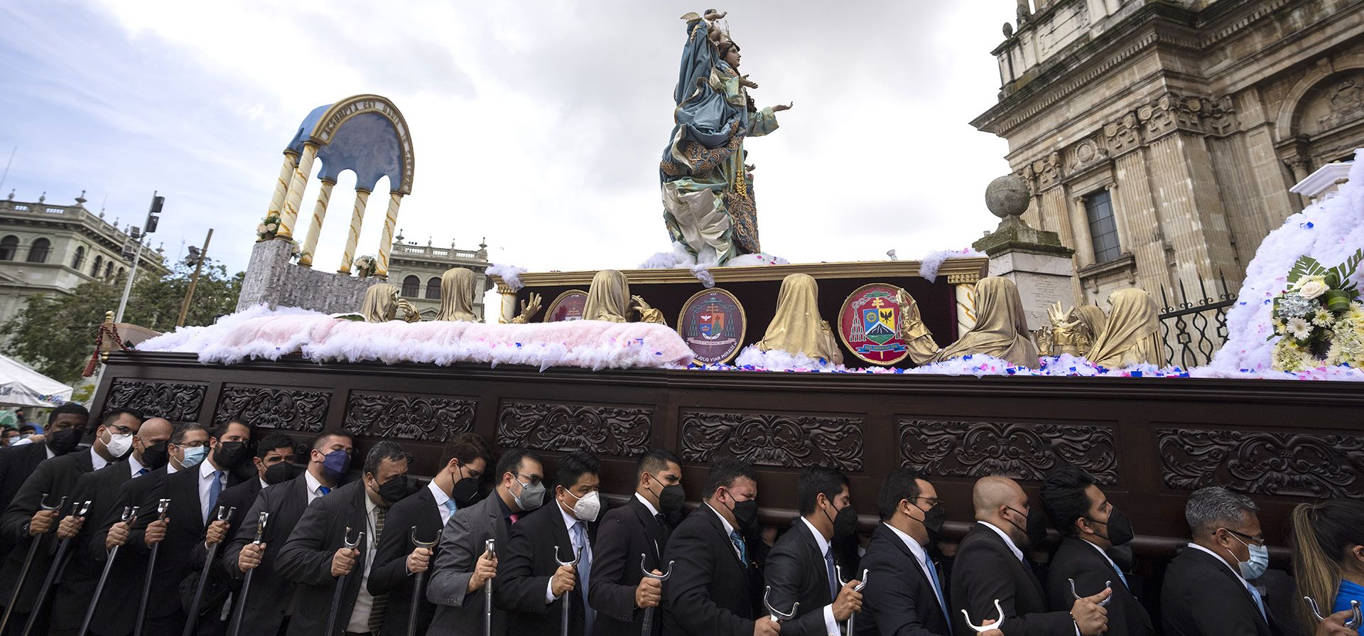 Católicos llevan una estatua de madera de La Asunción de la Virgen María durante una procesión en honor a la santa patrona de la Ciudad de Guatemala, el lunes 15 de agosto de 2022.