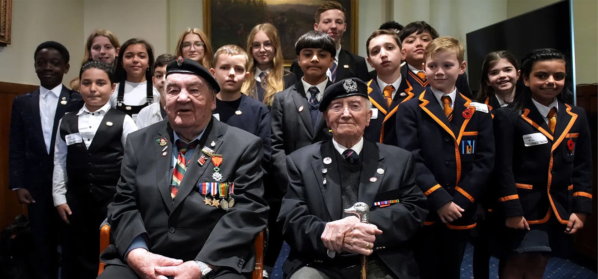 Los veteranos del Día D Richard Aldred (izquierda), de 99 años, que sirvió en la 7ª División Blindada del Regimiento Real de Tanques, y el embajador del monumento a la Normandía británica, Stan Ford, de 98 años, que sirvió en la Royal Navy, se reúnen con escolares en Londres, Reino Unido. Fotografía: Gareth Fuller/PA