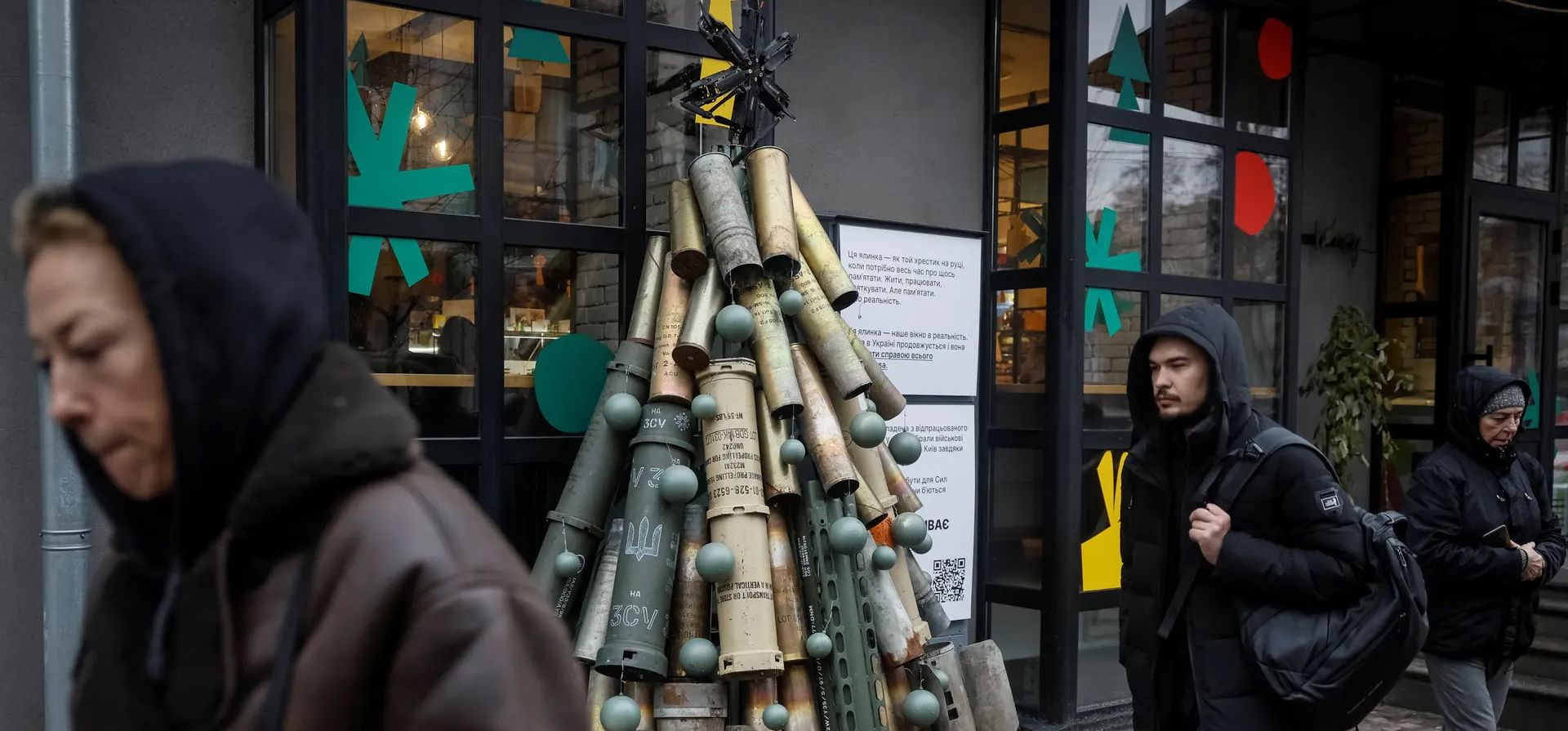 Los peatones pasan junto a un árbol de Navidad hecho con proyectiles de artillería usados y partes de cohetes, Kiev, Ucrania. Fotografía: Gleb Garanich/Reuters Los peatones pasan junto a un árbol de Navidad hecho con proyectiles de artillería usados y partes de cohetes, Kiev, Ucrania. Fotografía: Gleb Garanich/Reuters