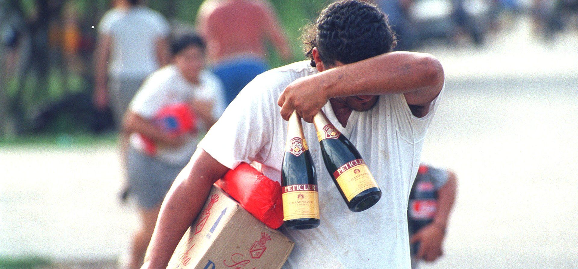 19/12/2001. En medio de los saqueos un hombre se hace de algunos productos pensando en pasar las fiestas.