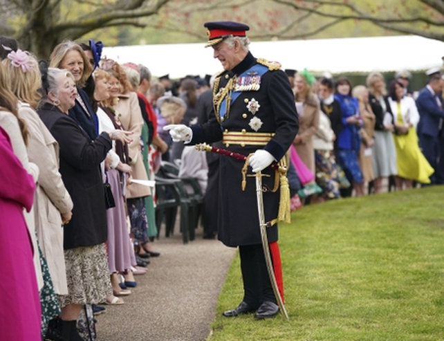 Carlos saluda al público durante una ceremonia en los jardines reales.&nbsp;