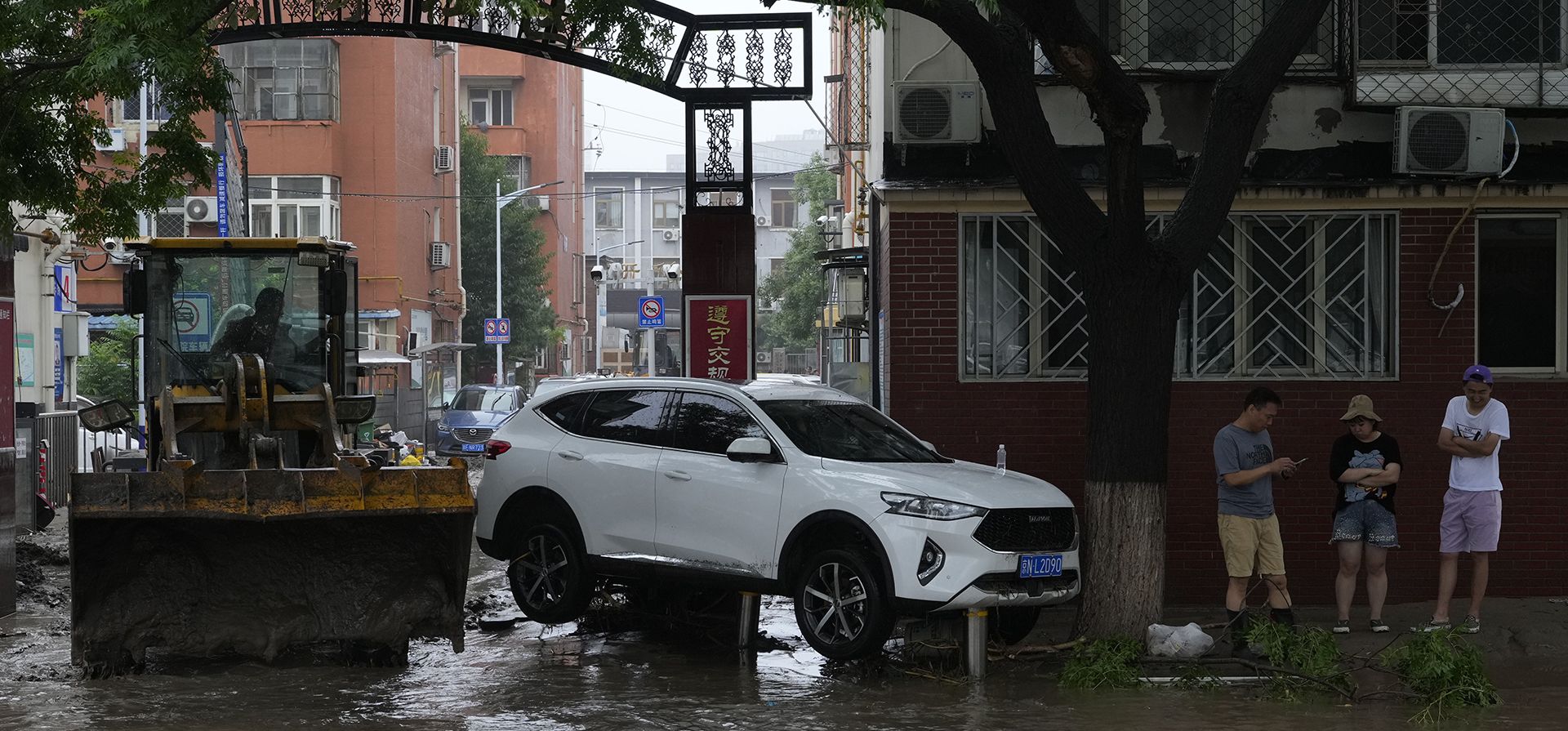Una excavadora extrae lodo de un vecindario cerca de un vehículo que quedó varado por las aguas de la inundación en el distrito de Mentougou, en las afueras de Beijing, el martes 1 de agosto de 2023. (Foto AP/Ng Han Guan) Una excavadora extrae lodo de un vecindario cerca de un vehículo que quedó varado por las aguas de la inundación en el distrito de Mentougou, en las afueras de Beijing, el martes 1 de agosto de 2023. (Foto AP/Ng Han Guan)