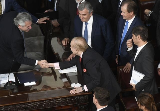 Carlos Menem le da la mano al presidente Alberto Fernández el día de su asunción.