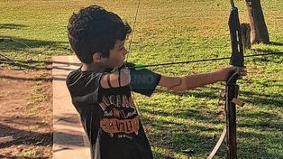 En acción. Santino usa un bracito ortopédico del lado izquierdo para ayudarse a sostener el arco y mantiene con el derecho la puntería de su flecha.