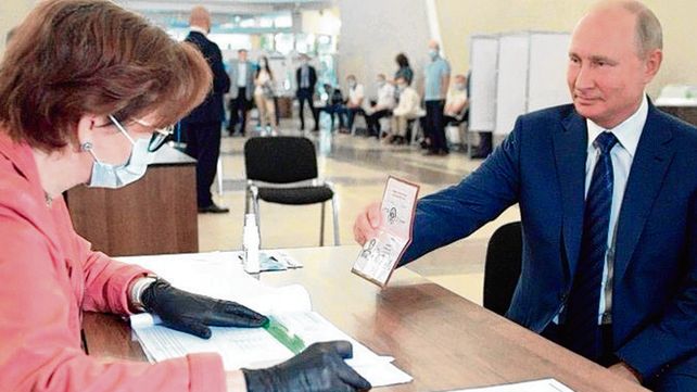 a votar. Putin muestra ayer su pasaporte a una funcionaria electoral.
