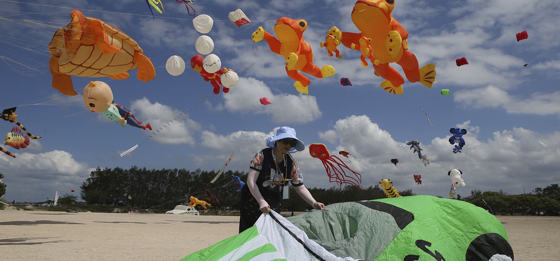 Una participante de China prepara su cometa durante el festival internacional de cometas de Denpasar en Sanur, Bali, Indonesia, el viernes 16 de agosto de 2024. (Foto AP/Firdia Lisnawati)