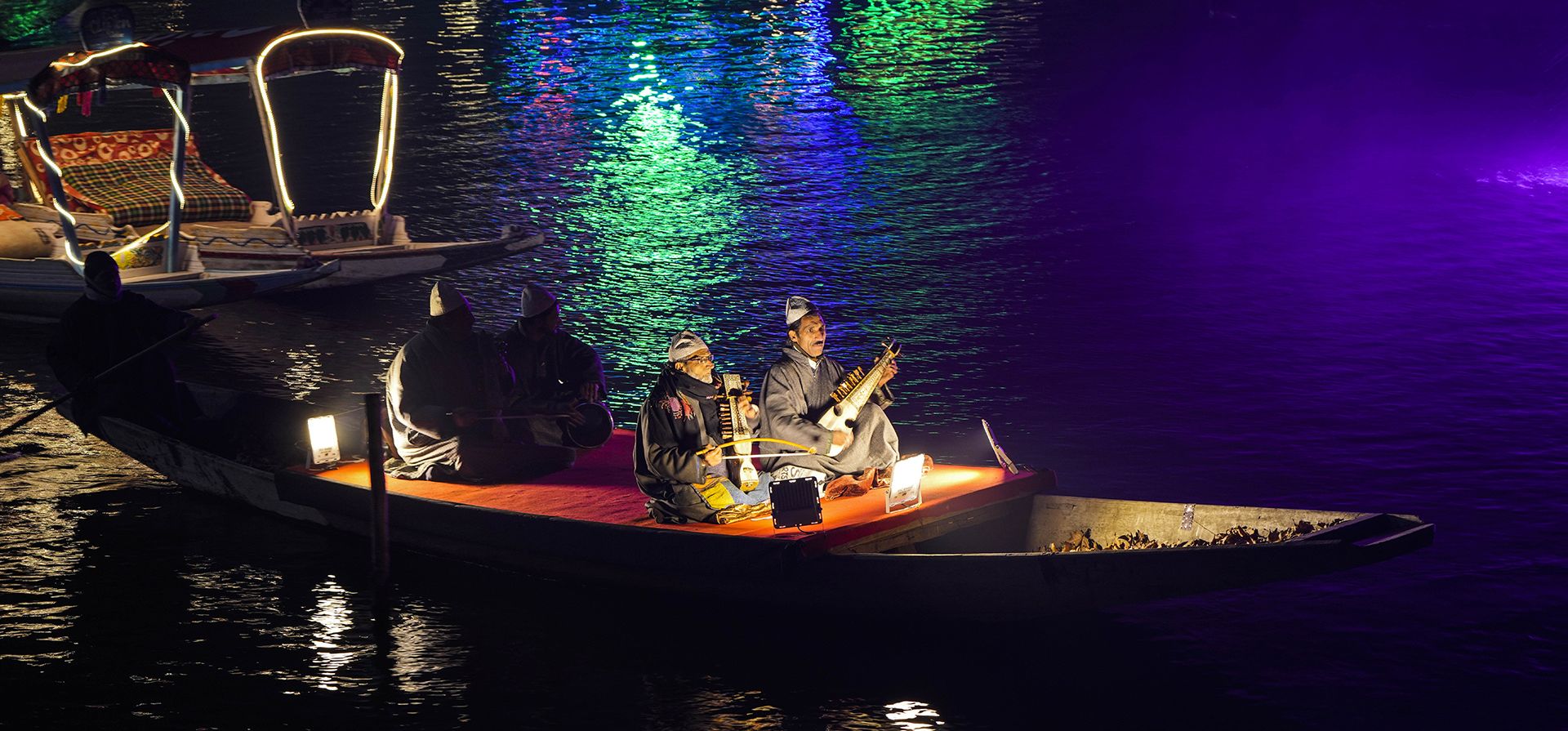 Músicos de Cachemira actúan durante un espectáculo de láser y un concierto en vivo organizado para impulsar el turismo de invierno en el lago Dal en Srinagar, Cachemira controlada por India, el miércoles 7 de diciembre de 2022. (Foto AP/Mukhtar Khan)