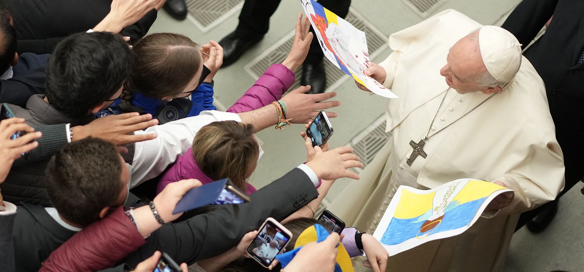 El papa Francisco mira los dibujos de los niños durante su audiencia general semanal en el Aula Pablo VI del Vaticano, el miércoles 13 de abril de 2022.