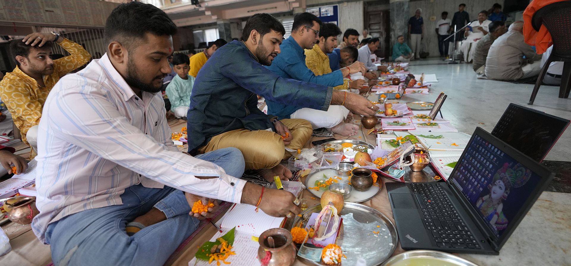 Comerciantes indios realizan rituales durante Chopda Pujan, una ceremonia de oración dedicada a la adoración de los libros de cuentas, con motivo de Diwali, el festival hindú de las luces, en el templo Swaminarayan en Ahmedabad, India, el lunes 24 de octubre de 2022.