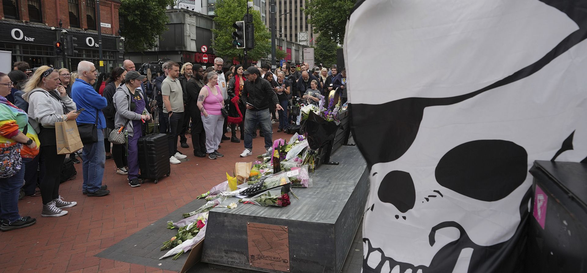 Los fans dejan flores para conmemorar la muerte de Ozzy Osbourne en el puente Black Sabbath en Birmingham, el miércoles 23 de julio de 2025. (Foto AP/Kin Cheung)
