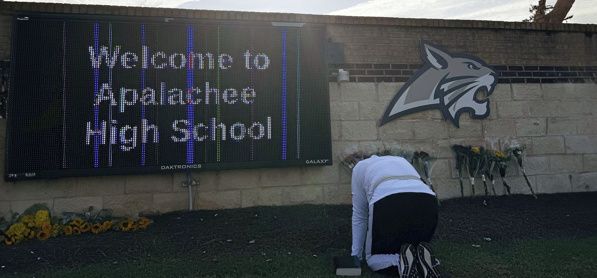 Una persona se arrodilla frente a unas flores colocadas en la entrada de la escuela secundaria Apalachee el jueves 5 de septiembre de 2024 en Winder, Georgia, un día después de los tiroteos mortales en la escuela. (Foto AP/Charlotte Kramon) Una persona se arrodilla frente a unas flores colocadas en la entrada de la escuela secundaria Apalachee el jueves 5 de septiembre de 2024 en Winder, Georgia, un día después de los tiroteos mortales en la escuela. (Foto AP/Charlotte Kramon)