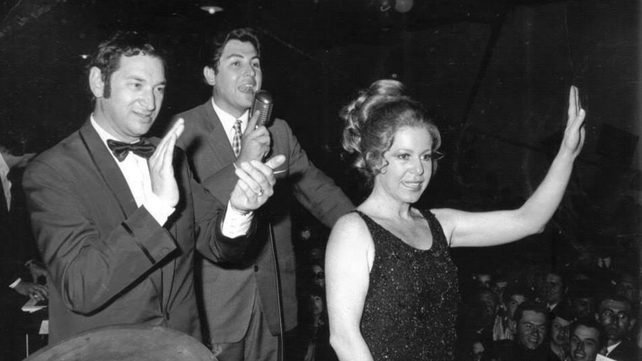 El locutor Hugo de Cruz aplaude mientras la cantante Estela Raval saluda al público reunido en 1970 en Tortugas (Santa Fe) para festejar el centenario de esa localidad.  Foto del perfil de Facebook de Rosario en el Recuerdo.