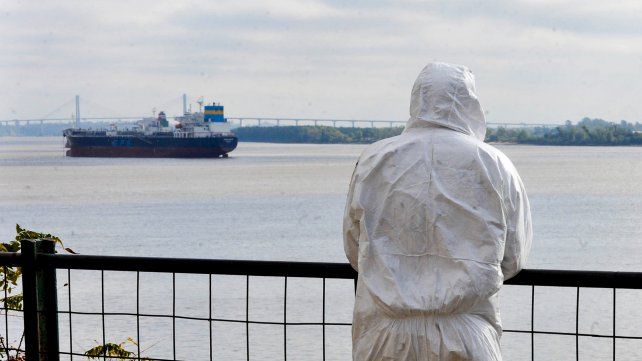 Un trabajador con traje de protección se toma unos minutos para contemplar el cause del río.